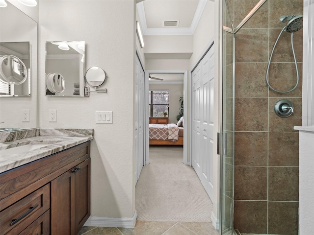 bathroom with tile patterned floors, ornamental molding, tiled shower, and vanity