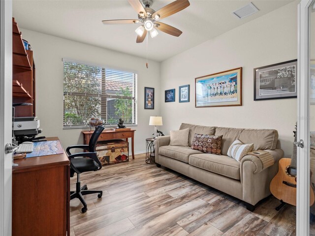 home office featuring ceiling fan and light hardwood / wood-style flooring