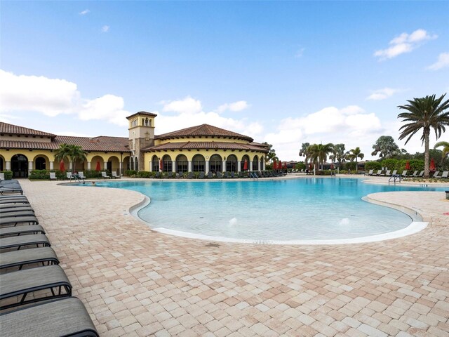 view of swimming pool with pool water feature and a patio area