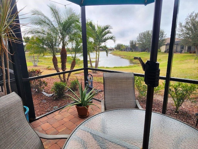 sunroom featuring a water view