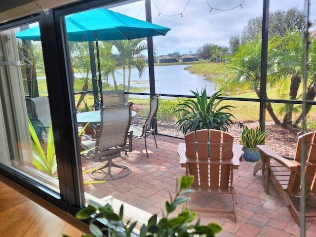 sunroom featuring a water view