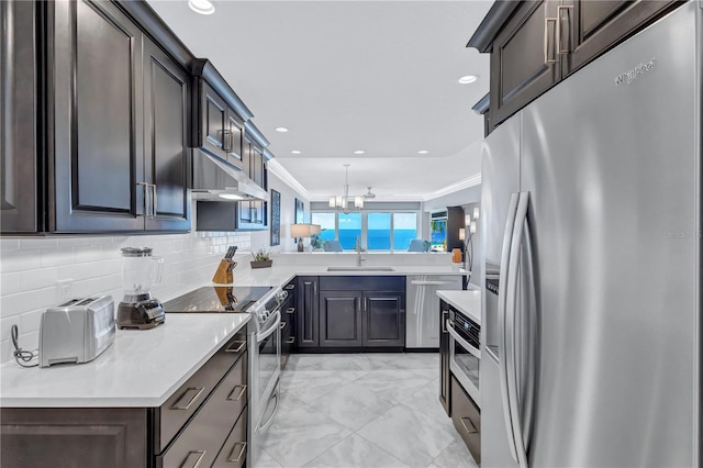 kitchen featuring decorative backsplash, stainless steel appliances, sink, an inviting chandelier, and range hood