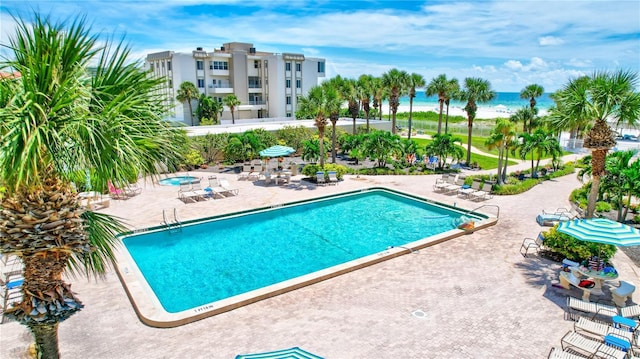 view of pool featuring a patio area and a water view