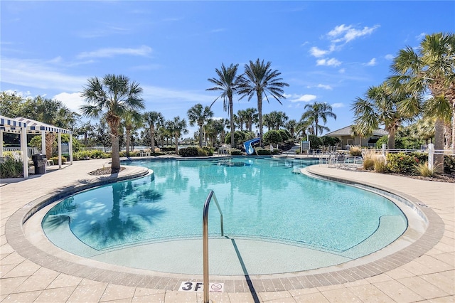 view of swimming pool with a patio and a water slide