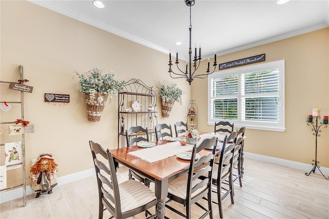 dining area with crown molding, a chandelier, and light wood-type flooring