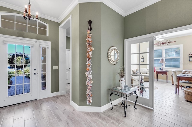 entrance foyer with a wealth of natural light, crown molding, and ceiling fan with notable chandelier