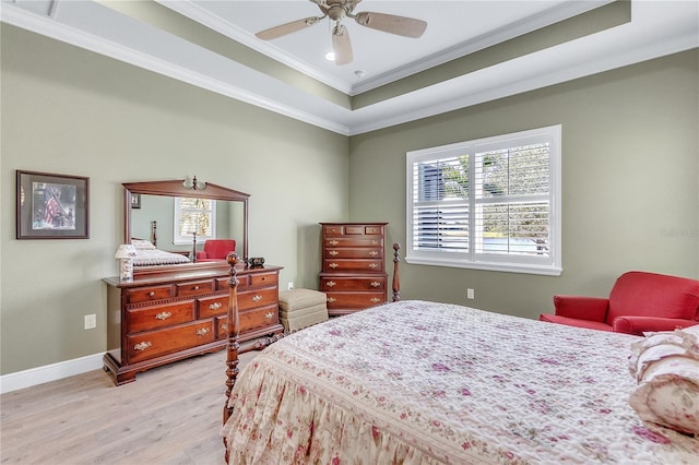 bedroom featuring a tray ceiling, crown molding, ceiling fan, and light hardwood / wood-style floors