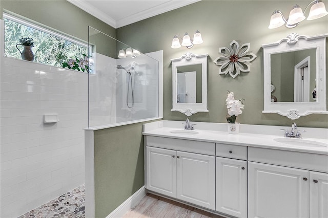 bathroom with tiled shower, vanity, and ornamental molding