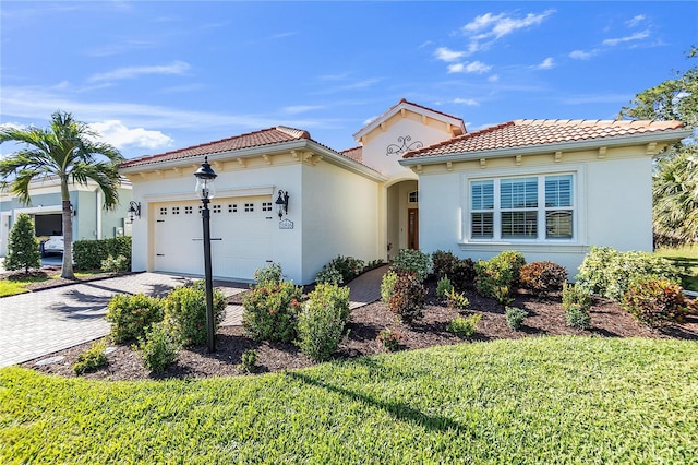 mediterranean / spanish house with a garage and a front yard