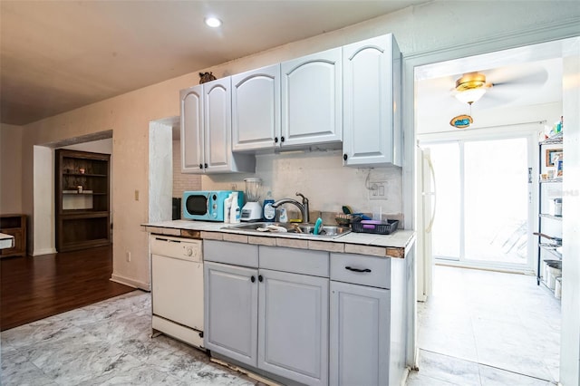 kitchen with tasteful backsplash, white dishwasher, tile counters, and sink