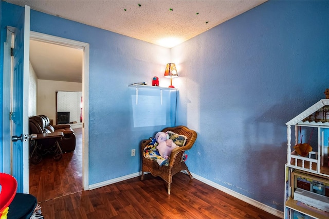 sitting room with dark hardwood / wood-style floors and a textured ceiling