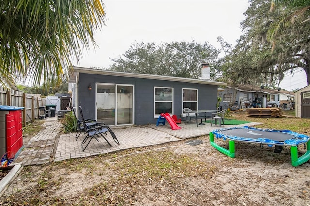 rear view of house with a patio and a trampoline