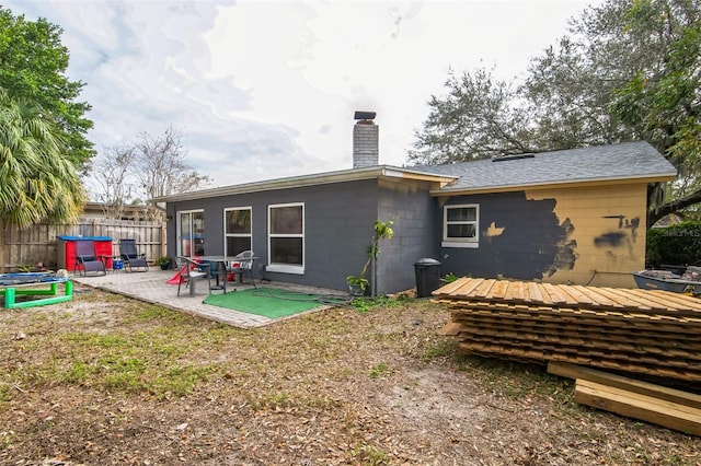 back of house with a trampoline and a patio