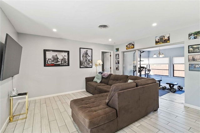 living room with an inviting chandelier and light hardwood / wood-style floors