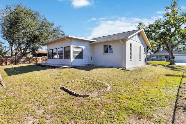 back of property with a yard and a sunroom