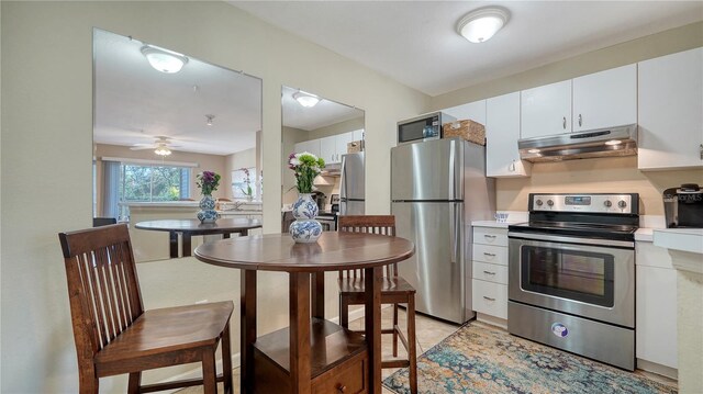 kitchen featuring white cabinetry, ceiling fan, and stainless steel appliances