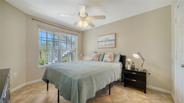 tiled bedroom featuring ceiling fan