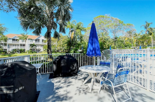 view of patio with area for grilling and a community pool