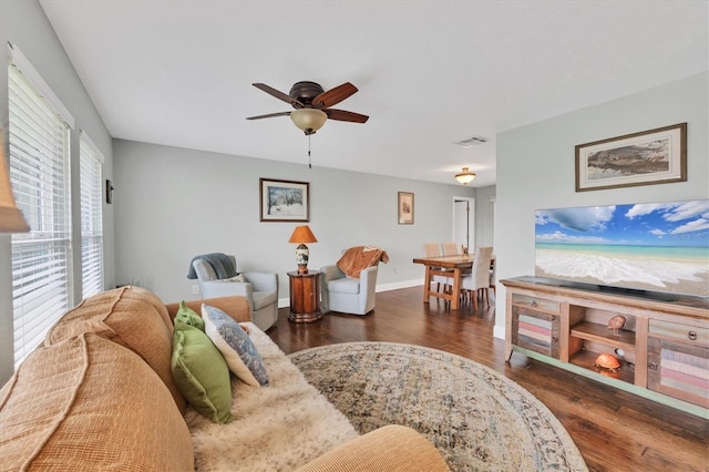 living room featuring ceiling fan and dark wood-type flooring