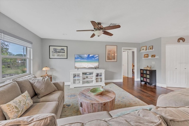 living room featuring ceiling fan and dark hardwood / wood-style flooring