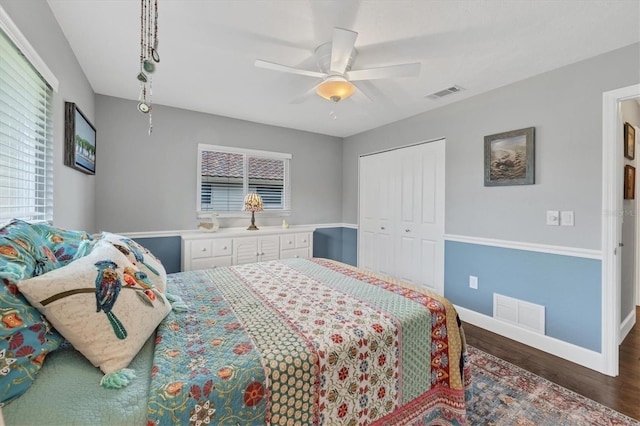 bedroom with ceiling fan, dark wood-type flooring, and a closet