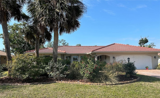 mediterranean / spanish-style home with a garage and a front yard