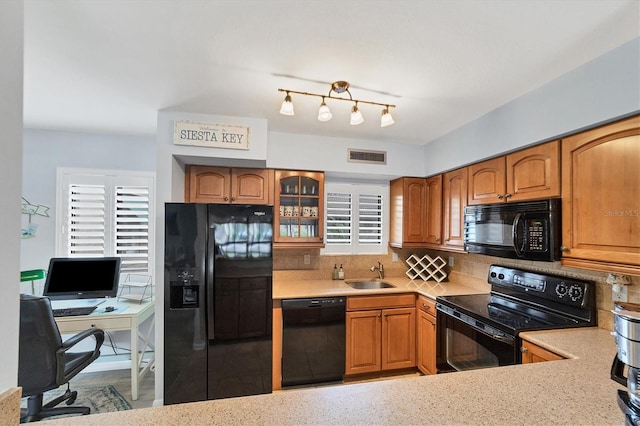 kitchen with backsplash, black appliances, and sink