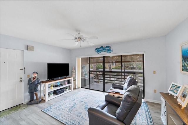 living room with ceiling fan and light hardwood / wood-style flooring