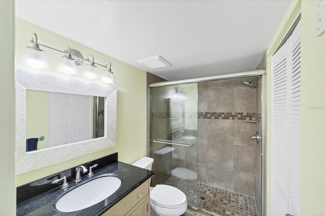 bathroom featuring toilet, an enclosed shower, and vanity