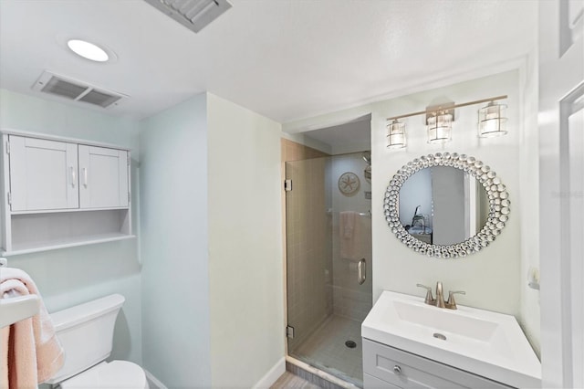 bathroom with vanity, a shower with shower door, and toilet