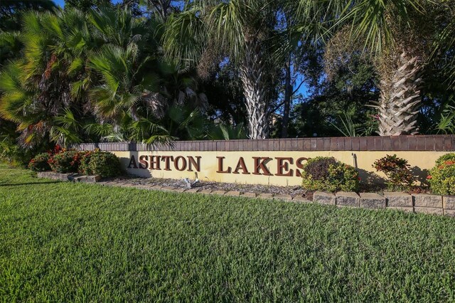 community / neighborhood sign with a yard