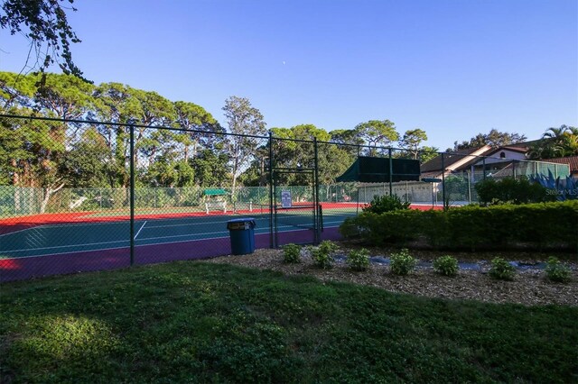 view of sport court featuring a lawn