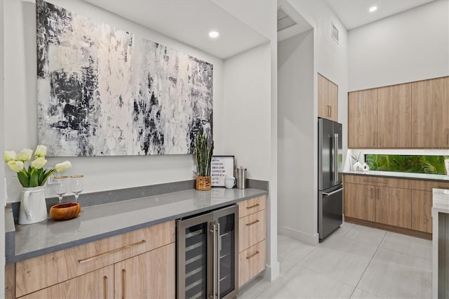 bar featuring light tile patterned floors, light brown cabinetry, beverage cooler, and high end refrigerator