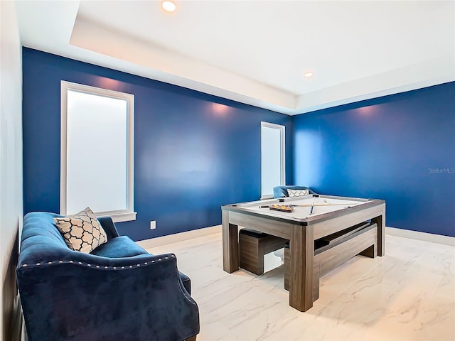 game room featuring a raised ceiling