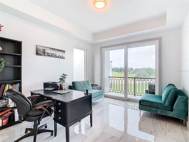 office space featuring a tray ceiling and built in features