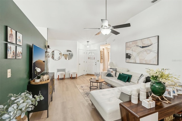 living room featuring ceiling fan, light hardwood / wood-style floors, and lofted ceiling