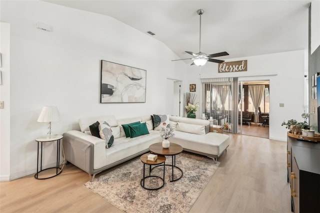 living room with ceiling fan, light hardwood / wood-style flooring, and lofted ceiling