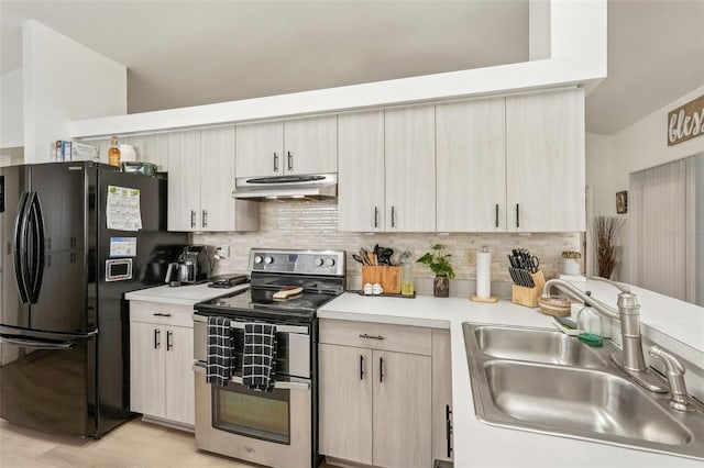 kitchen with sink, black fridge, stainless steel electric range oven, and tasteful backsplash