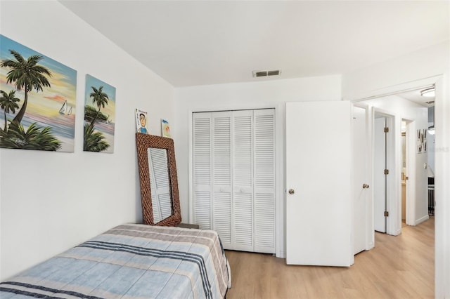 bedroom with light wood-type flooring and a closet