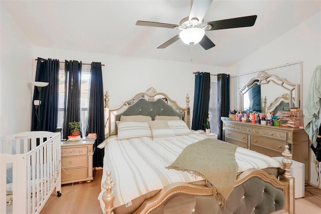 bedroom with ceiling fan, light hardwood / wood-style flooring, and lofted ceiling