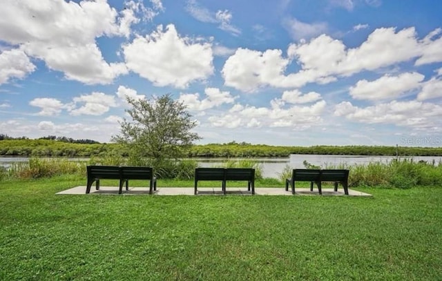 surrounding community featuring a water view and a lawn