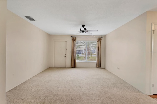 empty room featuring ceiling fan and light carpet