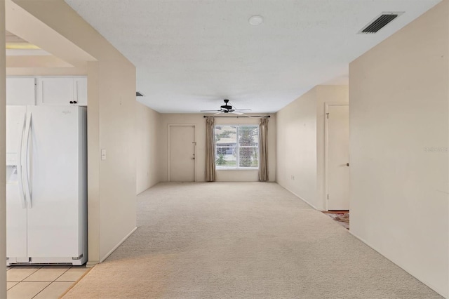 spare room featuring ceiling fan and light carpet