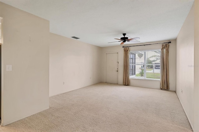 empty room featuring ceiling fan and light colored carpet