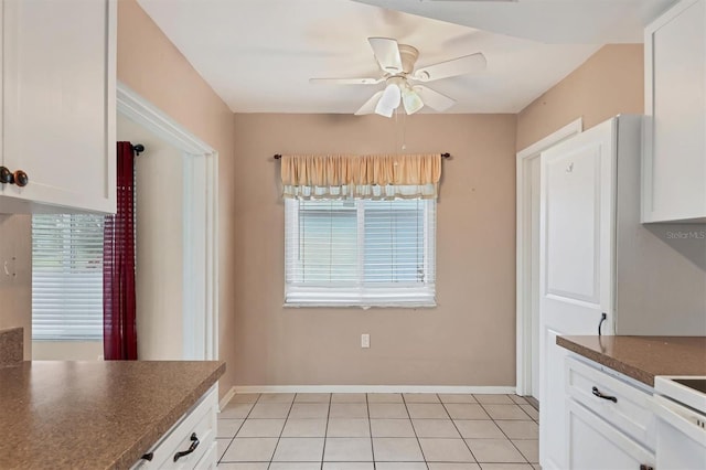 kitchen with light tile patterned floors, white cabinetry, ceiling fan, and a wealth of natural light