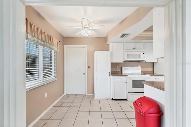 kitchen featuring white appliances, white cabinetry, ceiling fan, and light tile patterned floors