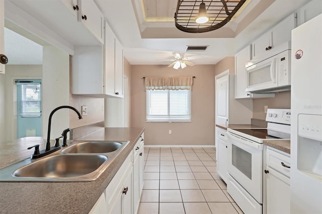 kitchen featuring white appliances, a raised ceiling, ceiling fan, white cabinets, and sink