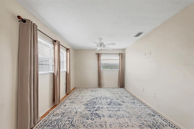 spare room featuring a textured ceiling and ceiling fan