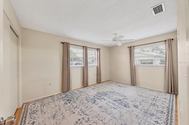 unfurnished bedroom featuring ceiling fan and a textured ceiling