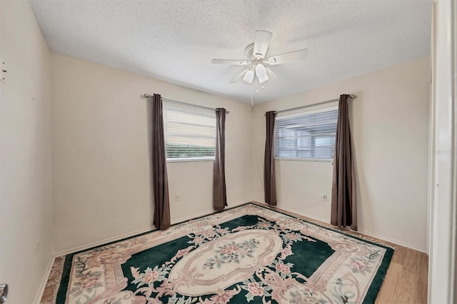 empty room featuring a textured ceiling, ceiling fan, and hardwood / wood-style flooring